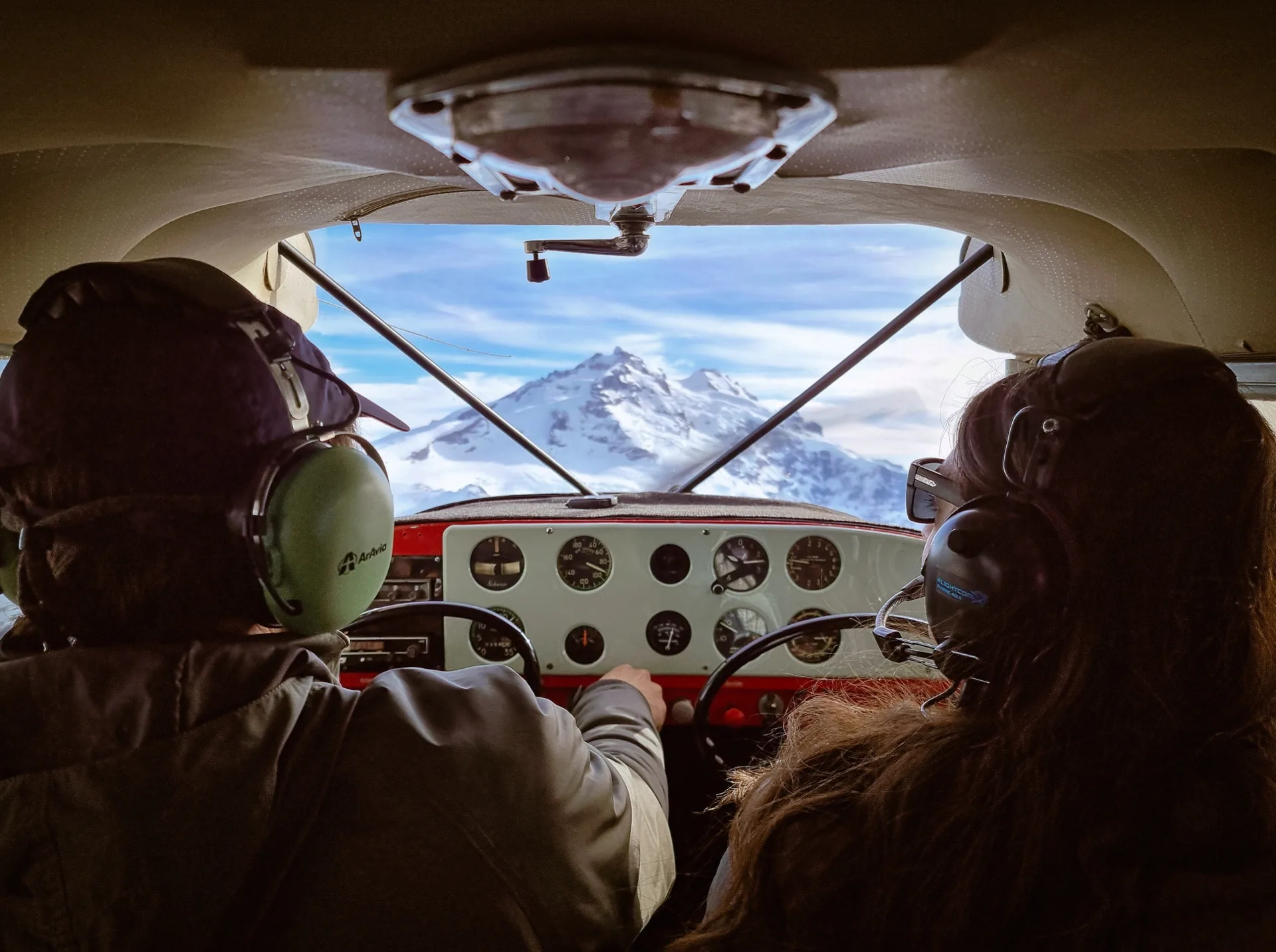 Pasajeros observando las montañas desde la cabina del avión